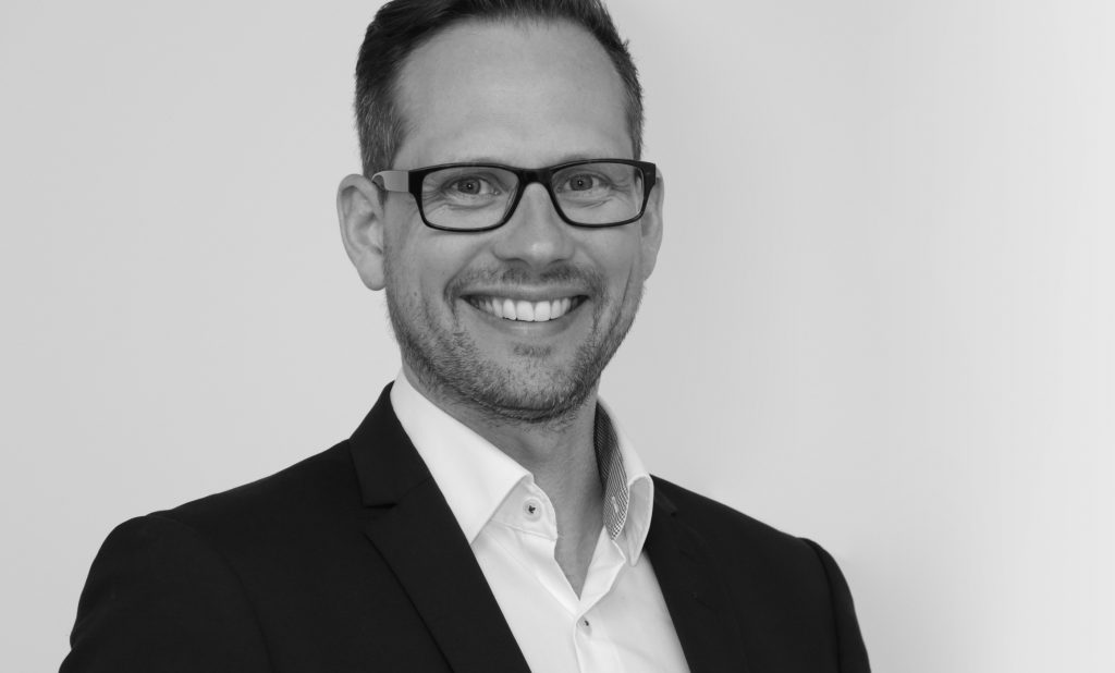 Freundlicher Mitarbeiter des Küchenvertriebs vom Hummel Küchenwerk. Bild ist in Schwarzweiß.