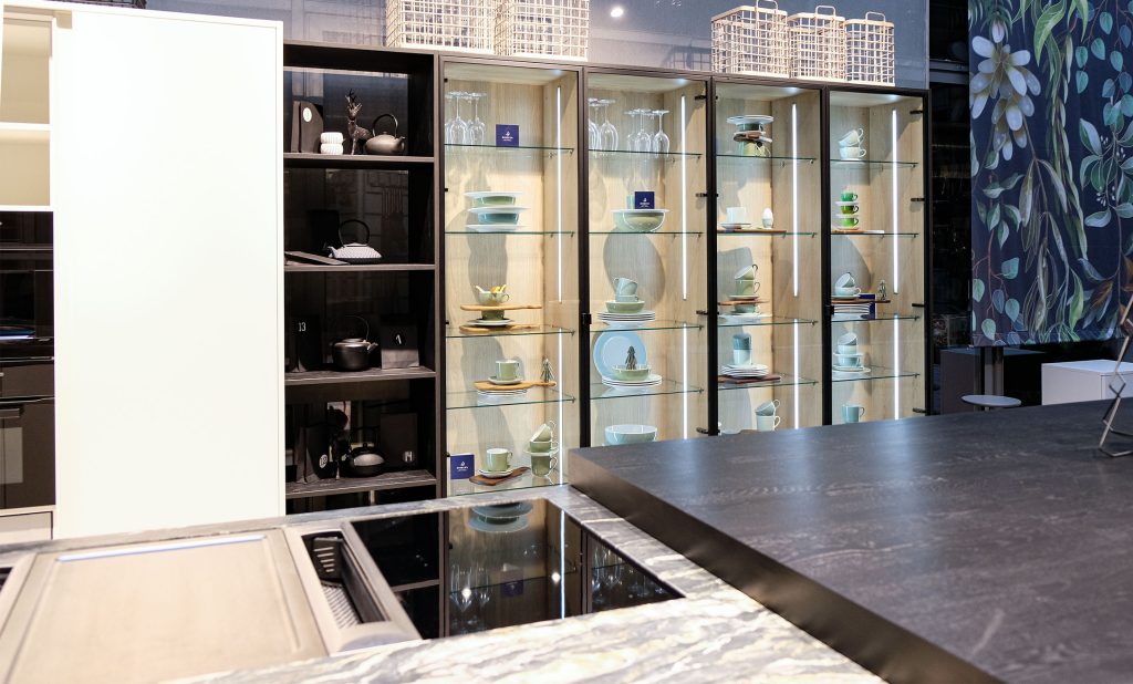 Beleuchtete Glasvitrinen mit Geschirr, Regal, Pocketdoorschrank für Küche oder Wohnzimmer. Hummel Küchenwerk Studio.