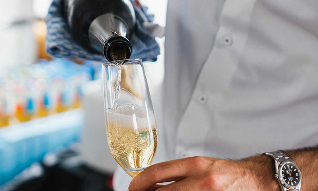 Ein Glas Sekt wird eingeschänkt.